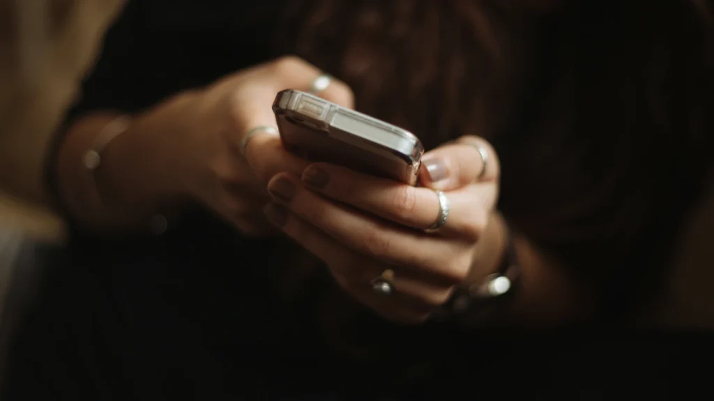 Eine Frau hält ein Smartphone in ihren Händen.