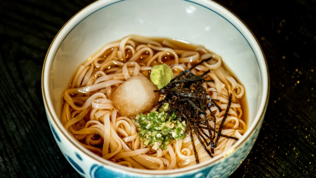Eine Suppenschale mit Hiyashi Chuka steht auf schwarzem Untergrund.
